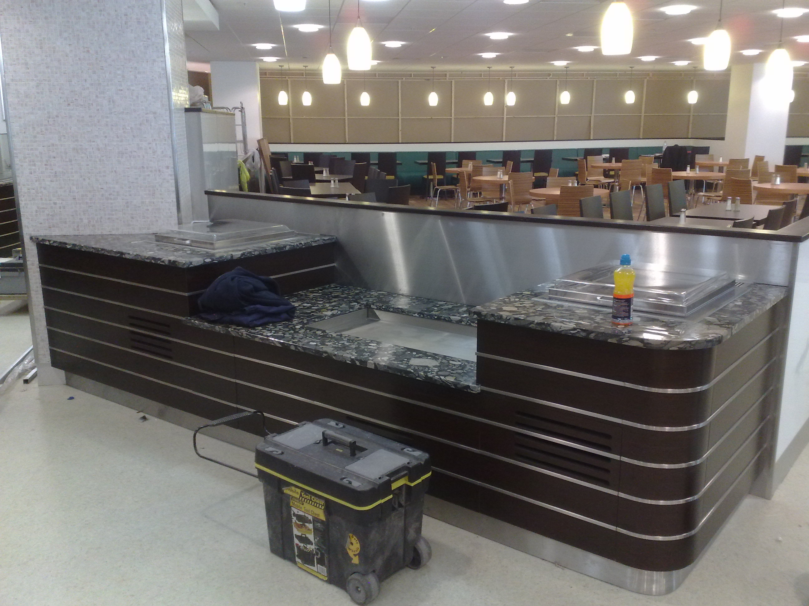 Department store –London.  Food servery – tops are granite . Fascia panels in wenge Laminate with inset stainless steel  bar