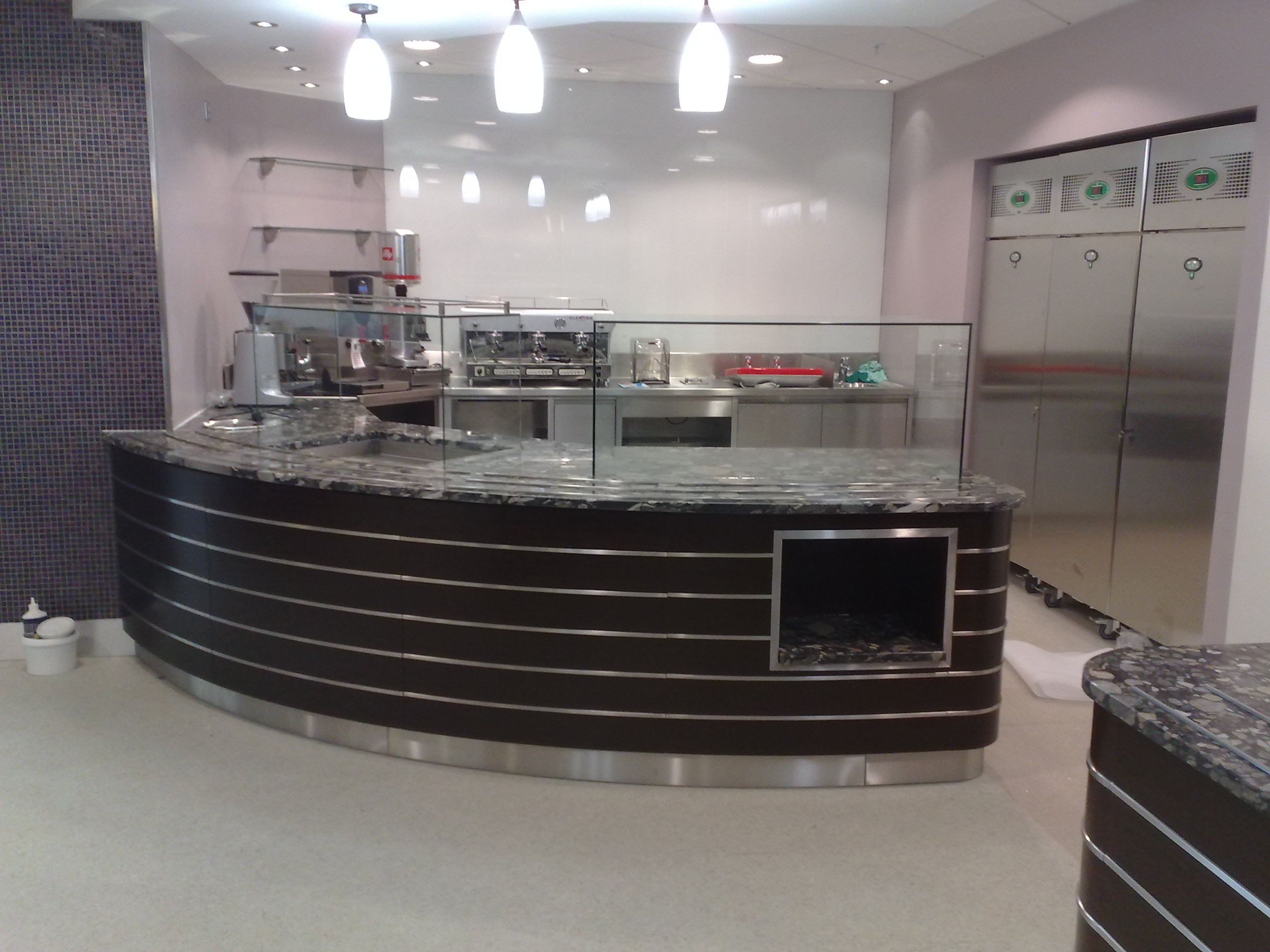 Department store –London.  Food servery – tops are granite . Fascia panels in wenge Laminate with inset stainless steel  bar
