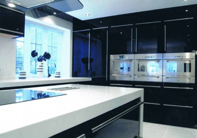 Black gloss doors with glacier white corian worktops and end panels with a corian sink