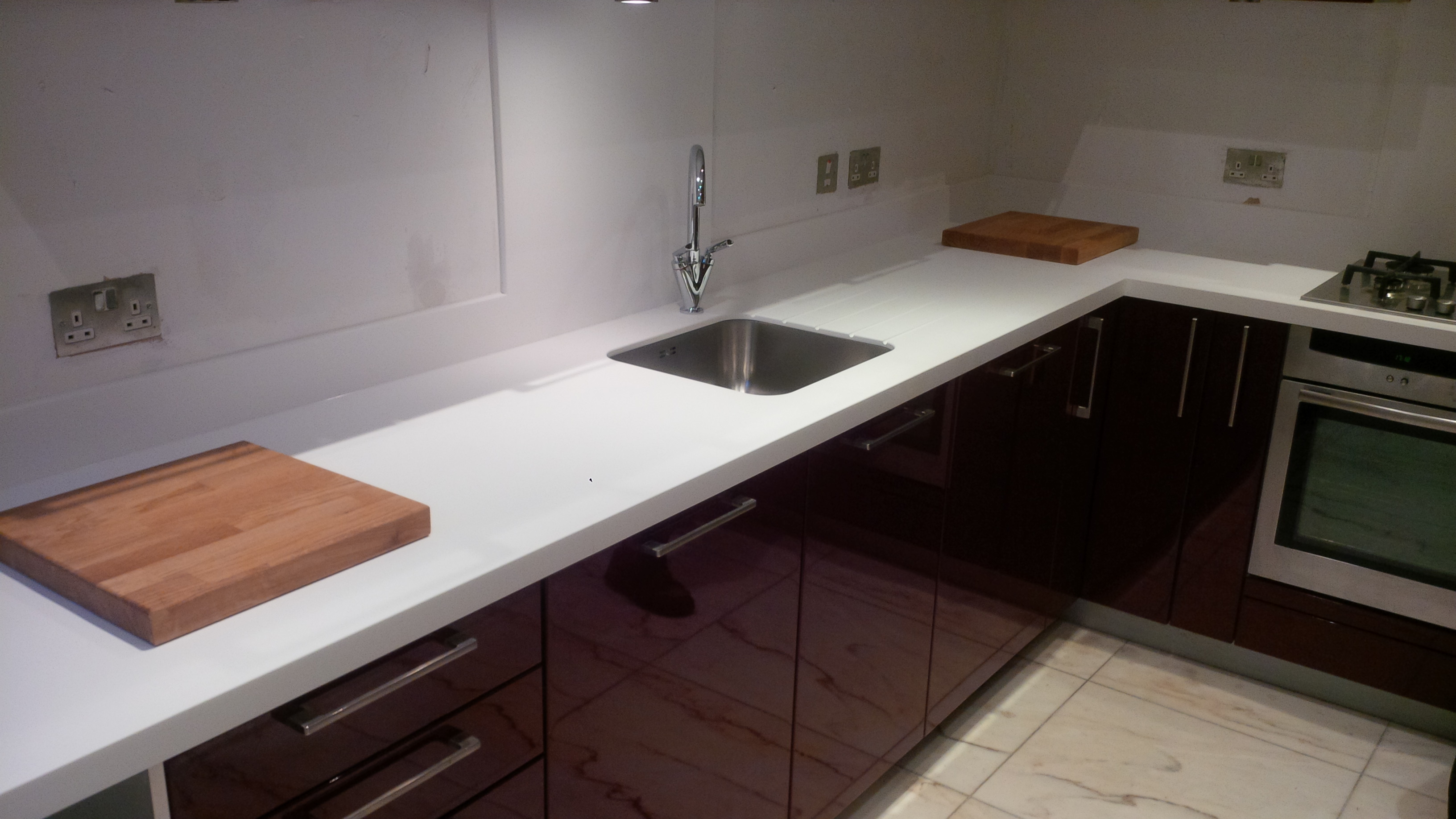 Replacement of granite worktops and upstands to glacier white corian and fitting of stainless steel  sink