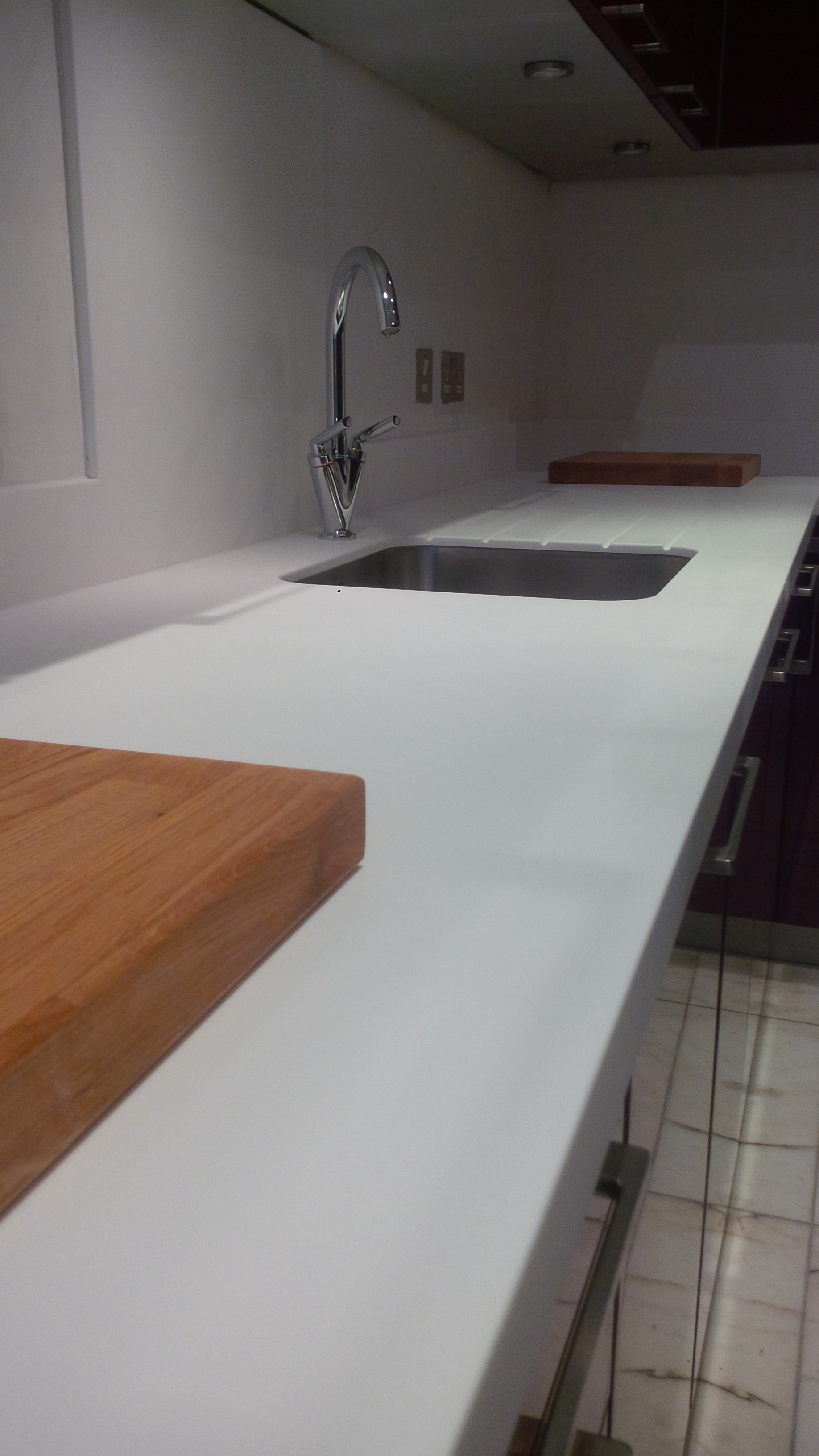 Replacement of granite worktops and upstands to glacier white corian and fitting of stainless steel  sink, by Designed Bespoke Joinery 1